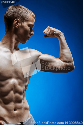 Image of Fit young man with beautiful torso on blue background