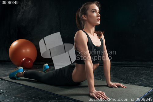 Image of Beautiful slim brunette doing some push ups a the gym