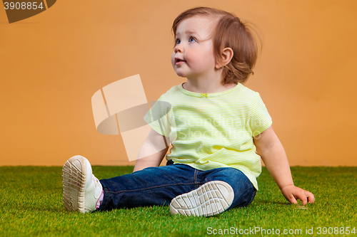 Image of One cute baby girl on orange background