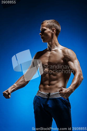 Image of Fit young man with beautiful torso on blue background