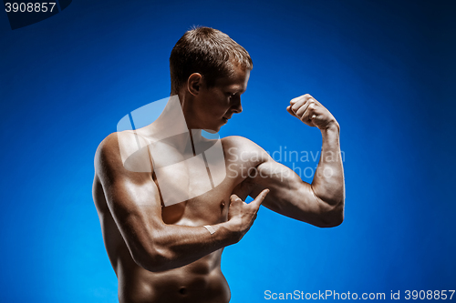 Image of Fit young man with beautiful torso on blue background