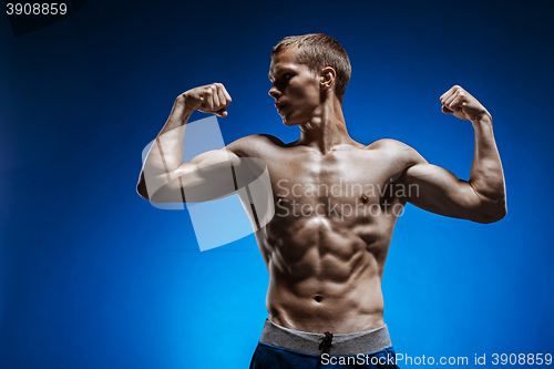 Image of Fit young man with beautiful torso on blue background