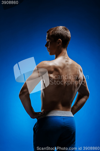 Image of Fit young man with beautiful torso on blue background
