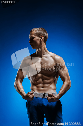 Image of Fit young man with beautiful torso on blue background