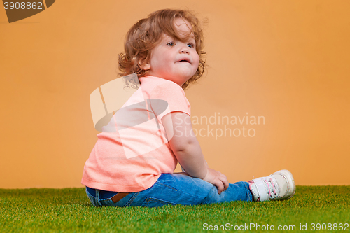 Image of One cute baby girl on orange background
