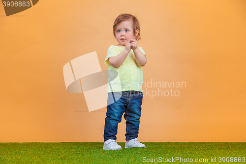 Image of One cute baby girl on orange background