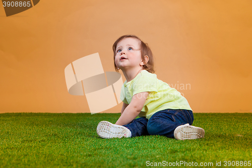 Image of One cute baby girl on orange background