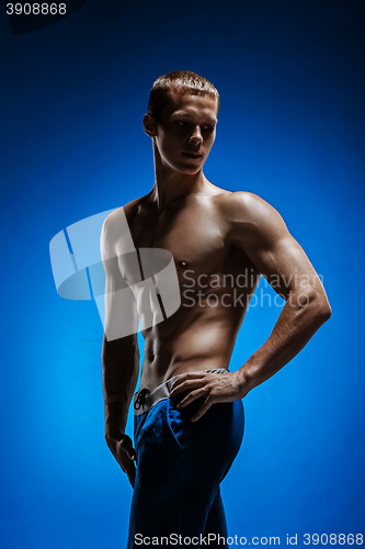 Image of Fit young man with beautiful torso on blue background