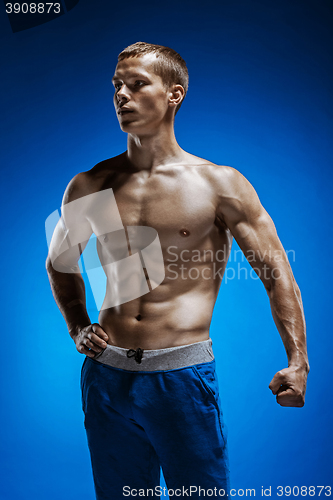 Image of Fit young man with beautiful torso on blue background