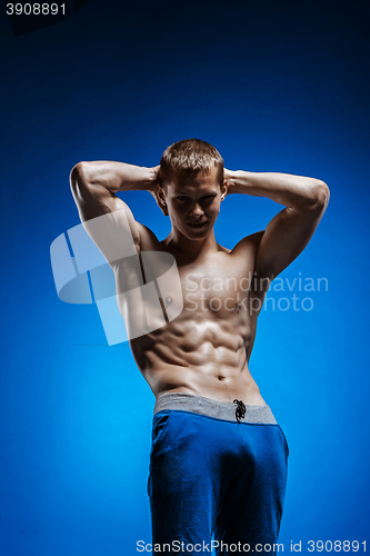 Image of Fit young man with beautiful torso on blue background