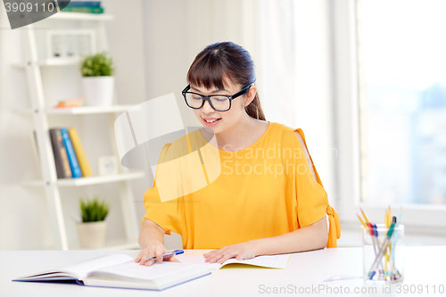 Image of happy asian young woman student learning at home