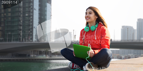 Image of happy young woman with tablet pc and headphones