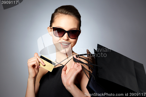 Image of happy woman with credit card and shopping bags