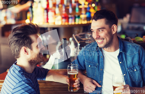 Image of happy male friends drinking beer at bar or pub