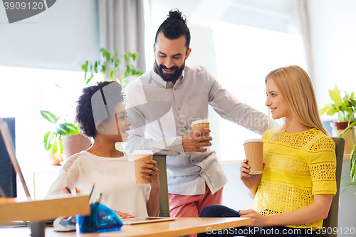 Image of business team with coffee cups talking at office