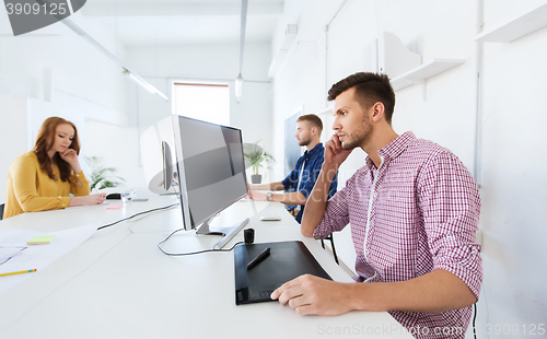 Image of man or designer with computer and tablet at office