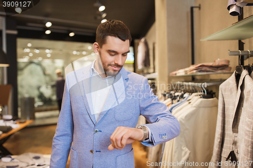 Image of happy man in jacket with watch at clothing store