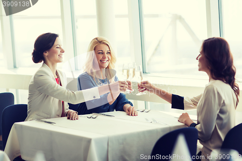 Image of happy women drinking champagne at restaurant