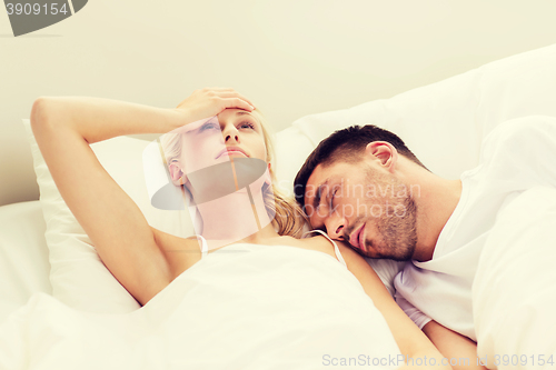 Image of couple sleeping in bed at home