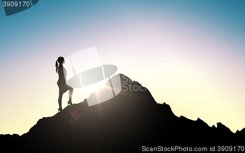 Image of silhouette of businesswoman raising up to mountain