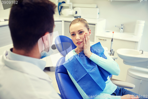 Image of male dentist with woman patient at clinic