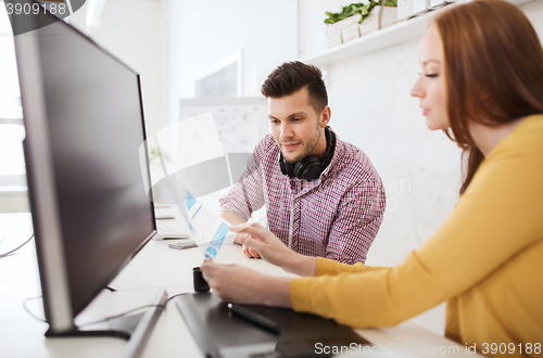 Image of happy creative team with papers at office