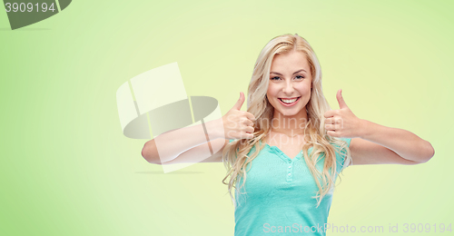 Image of happy woman or teenage girl showing thumbs up