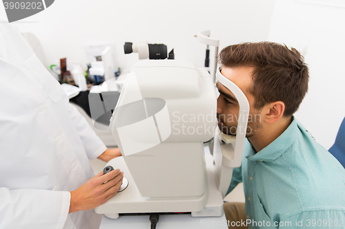 Image of optician with autorefractor and patient at clinic