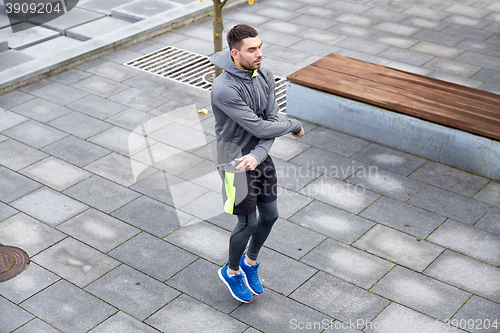 Image of man exercising with jump-rope outdoors