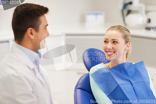 Image of happy male dentist with woman patient at clinic