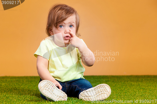 Image of One cute baby girl on orange background