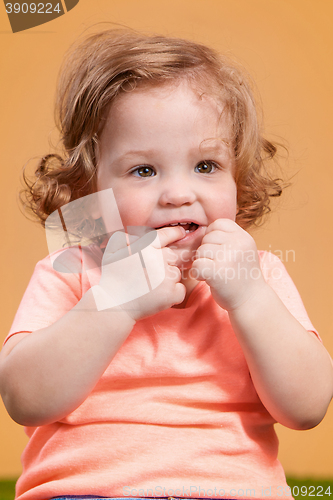 Image of One cute baby girl on orange background