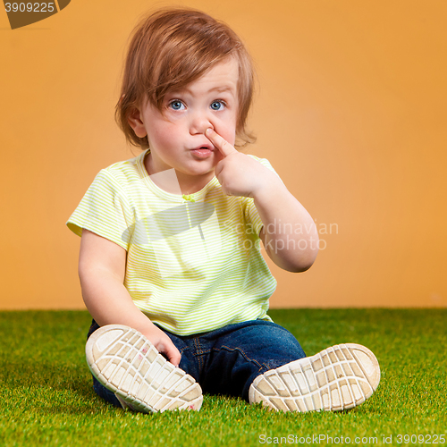 Image of One cute baby girl on orange background