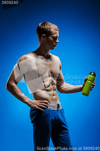 Image of Fit young man with beautiful torso on blue background