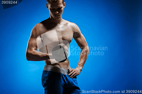 Image of Fit young man with beautiful torso on blue background