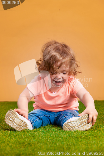 Image of One cute baby girl on orange background