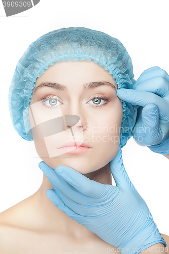 Image of Plastic surgery concept. Doctor hands in gloves touching woman face