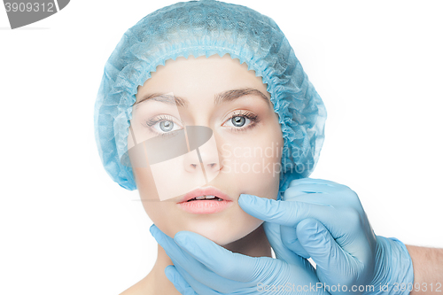 Image of Plastic surgery concept. Doctor hands in gloves touching woman face