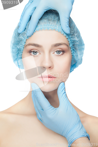 Image of Plastic surgery concept. Doctor hands in gloves touching woman face