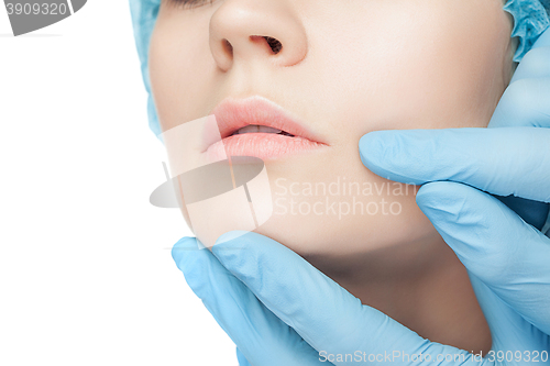 Image of Plastic surgery concept. Doctor hands in gloves touching woman face