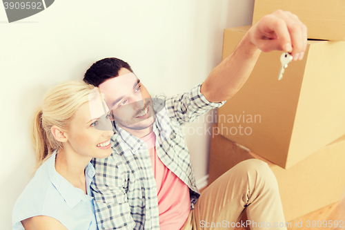 Image of couple with key and boxes moving to new home