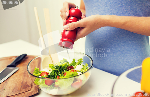 Image of close up of woman cooking vegetable salad at home