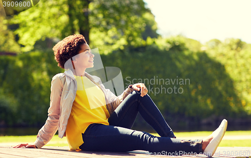 Image of happy african american young woman in summer park