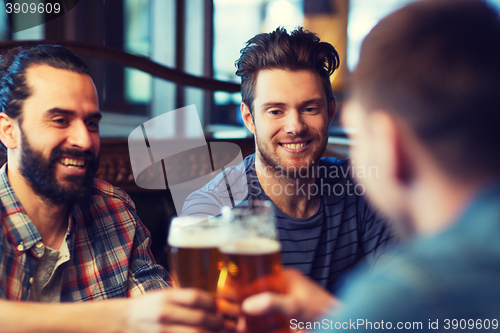 Image of happy male friends drinking beer at bar or pub