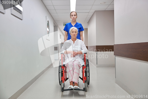 Image of nurse with senior woman in wheelchair at hospital