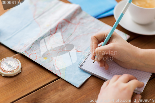 Image of close up of traveler hands with notepad and pencil