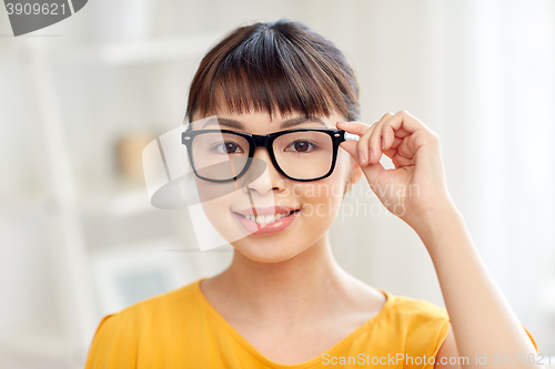 Image of happy asian young woman in glasses at home