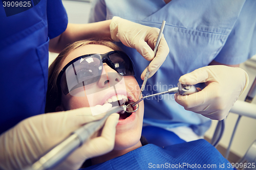 Image of female dentists treating patient girl teeth