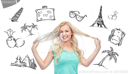 Image of smiling young woman holding strands of her hair