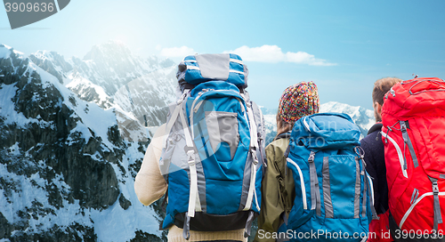 Image of travelers with backpacks hiking in mountains